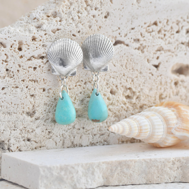 Los pendientes "Cerdeña" capturan la esencia del estilo de vida mediterráneo, trayendo la tranquilidad del mar a tu look diario. Estos pendientes presentan una concha marina elaborada en plata, la adición de una piedra de turquesa genuina aporta un toque vibrante de color, que recuerda a las aguas cristalinas de las playas de Cerdeña, haciéndolos llamativos y elegantes. Almakaia by Heike Otten